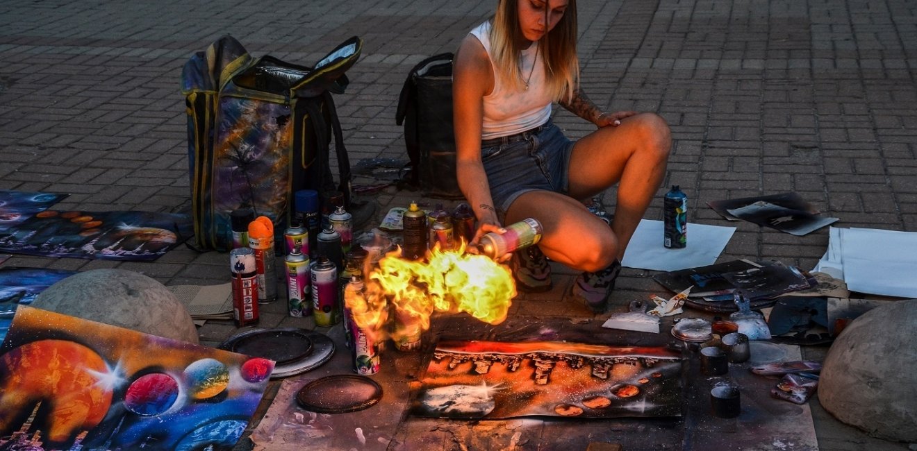 Woman making art on the street with fire