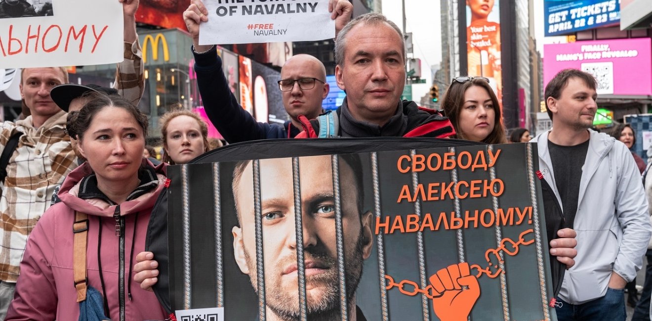 Protestors demanding action to free Russian political prisoners hold up a sign of Alexei Navalny