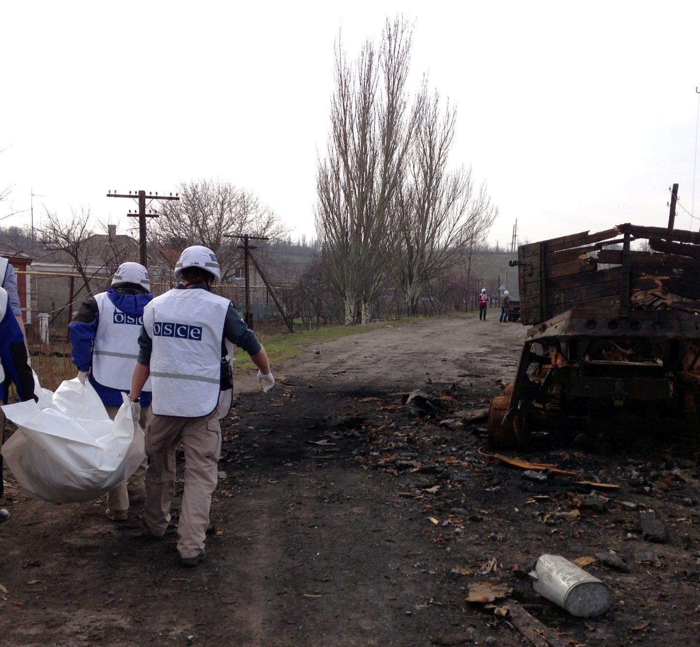 OSCE monitors recovering a body from a house in Shyrokyne, Ukraine.