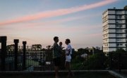 Husband, wife, and baby on balcony overlooking city 