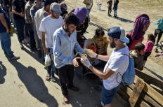 Refugees waiting in line for food.