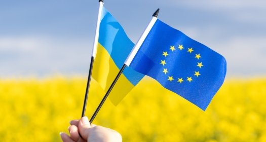 Flags with symbols of the European Union and Ukraine held in a girl's hand, Concept, Acceptance of the Ukrainian candidacy to apply for EU membership