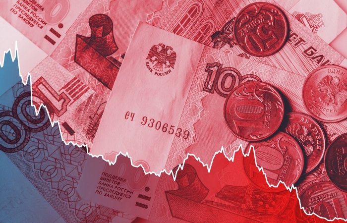 A line graph indicating the ruble's plummeting value overlays a close-up shot of ruble notes and coins.