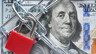 Photo of a lock and chain across a $100 bill