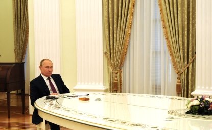 Vladimir putin alone at a long table