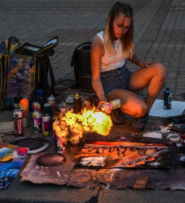 Woman making art on the street with fire