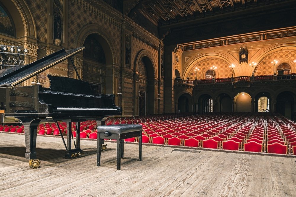 Image of piano on concert hall stage 