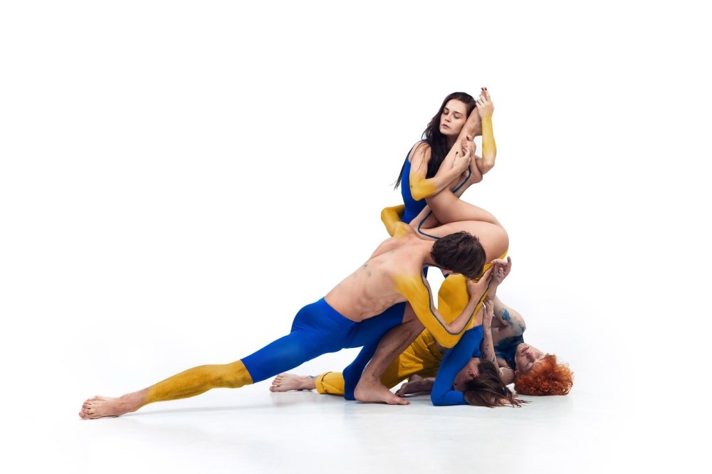 group of modern ballet dancers painted in blue and yellow colors of Ukrainian flag