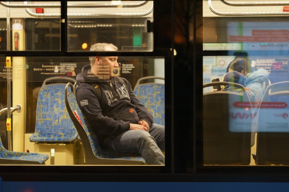 Image of a man on a bus through the bus's window 