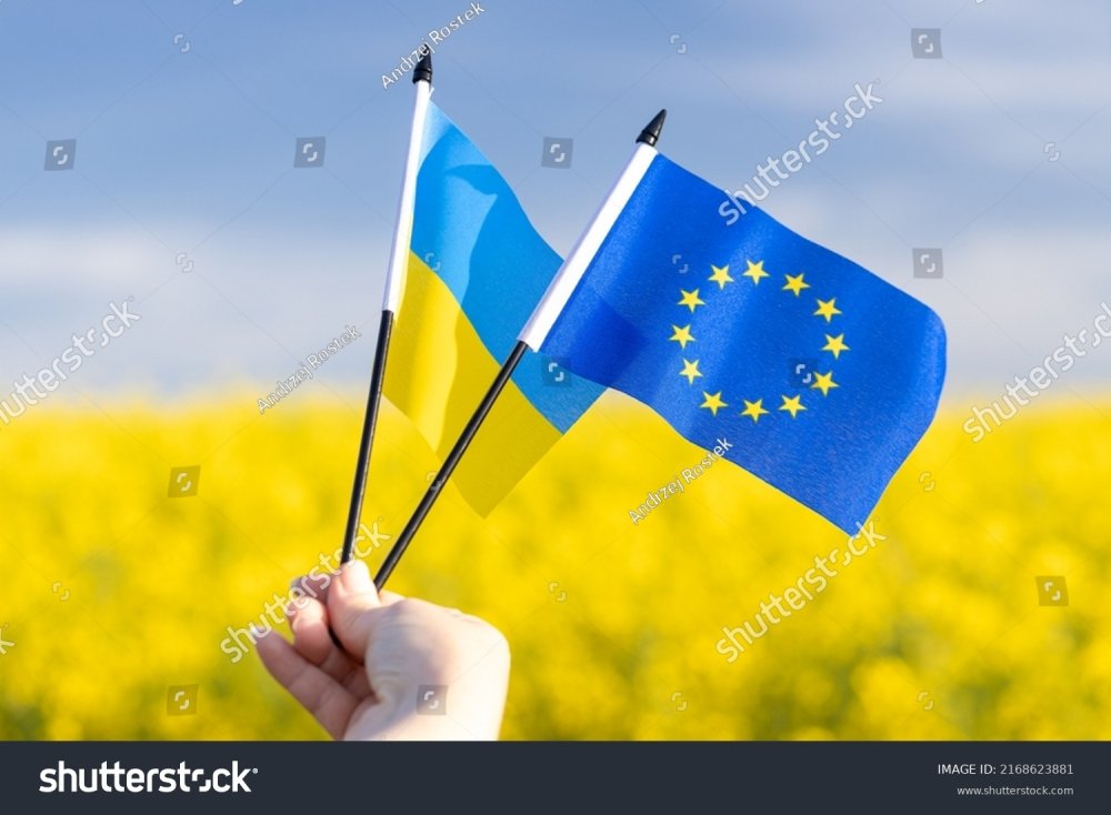 Flags with symbols of the European Union and Ukraine held in a girl's hand, Concept, Acceptance of the Ukrainian candidacy to apply for EU membership