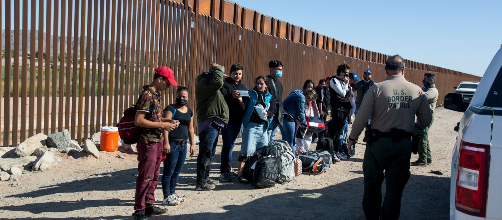 Migrants from Columbia wait to be processed after turning themselves over to authorities at the United States and Mexico border May 12, 2021 in Yuma, Arizona.