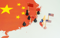 Chess pawns representing China on one side and the US on the side of a map of Taiwan