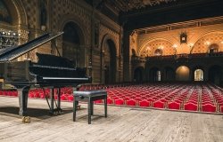 Image of piano on concert hall stage 