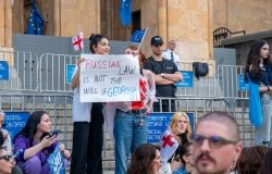 Protesters at Georgian parliament building in Tbilisi with flags and placards